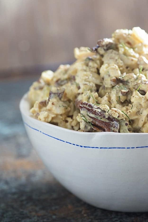 Chicken salad in a white bowl with a blue stripe.