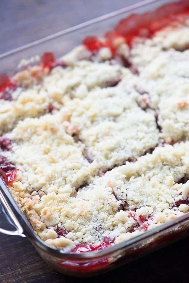 Cherry pie bars cut into squares in a glass baking pan.