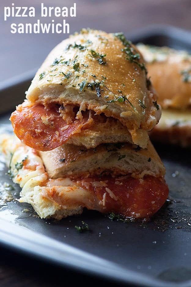 Two pieces of french bread pizza sandwiches on a baking sheet.