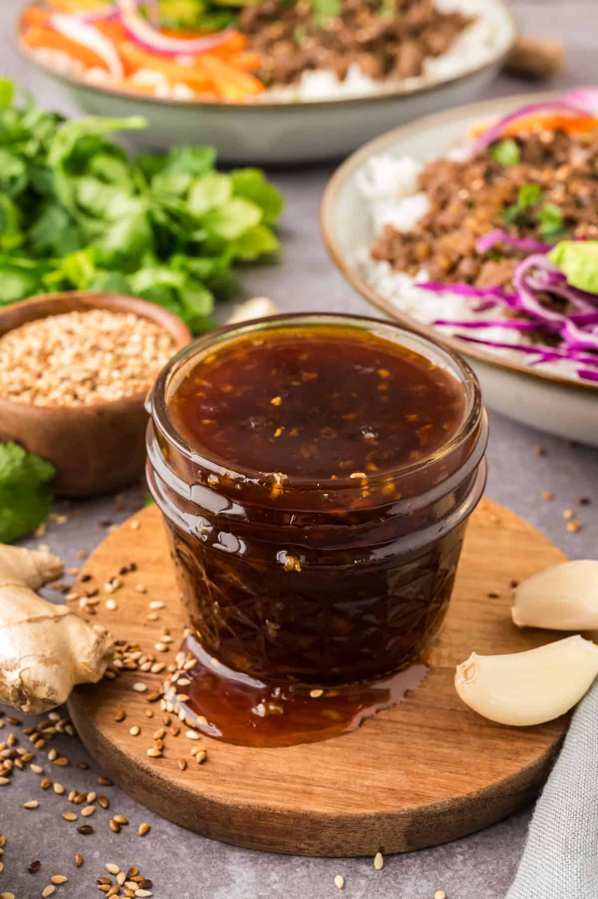 Korean BBQ Sauce in small jar on wooden board.