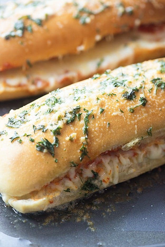 A close up of a pizza bread sandwich next to a baking sheet.