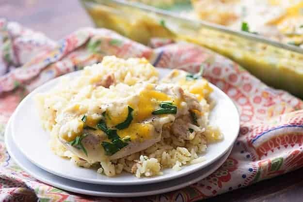 Chicken and rice on a small white plate on top of a cloth napkin.