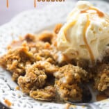A decorative white plate of pumpkin cobbler with ice cream on top.