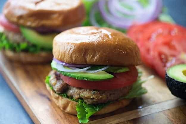 A close up of a sandwich sitting on top of a wooden cutting board