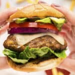 Hands holding a turkey burger.