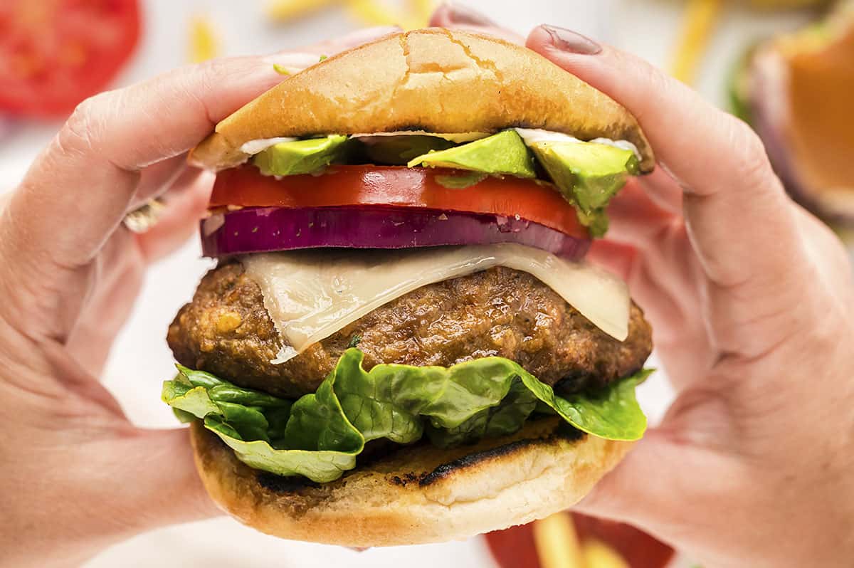 Hands holding a turkey burger.