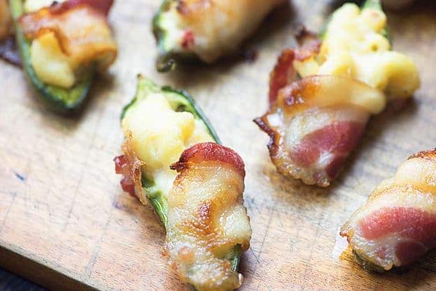 Close up of a few jalapeno poppers on ao cutting board.