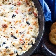 This olive cheese dip is the perfect football food! It's full of creamy melted cheese and salty green and black olives!