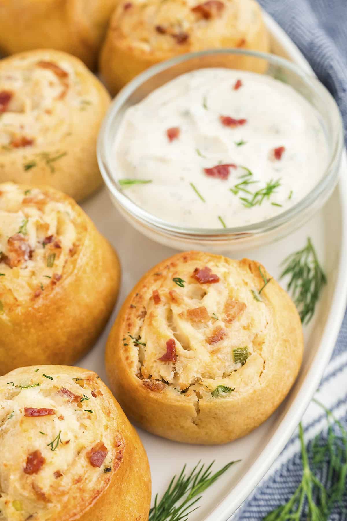 Cream cheese pinwheels filled with chicken and bacon on white plate.