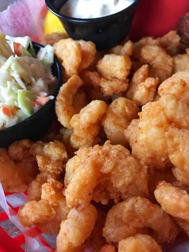 Close up of fried food next to a cup of cole slaw.