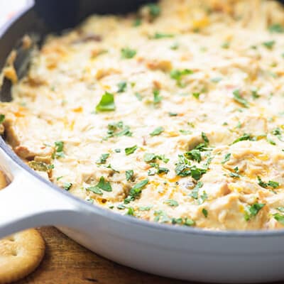 A white cast iron skillet of chicken dip.