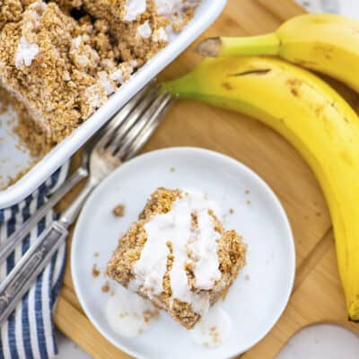 Cake on white plate next to bananas.