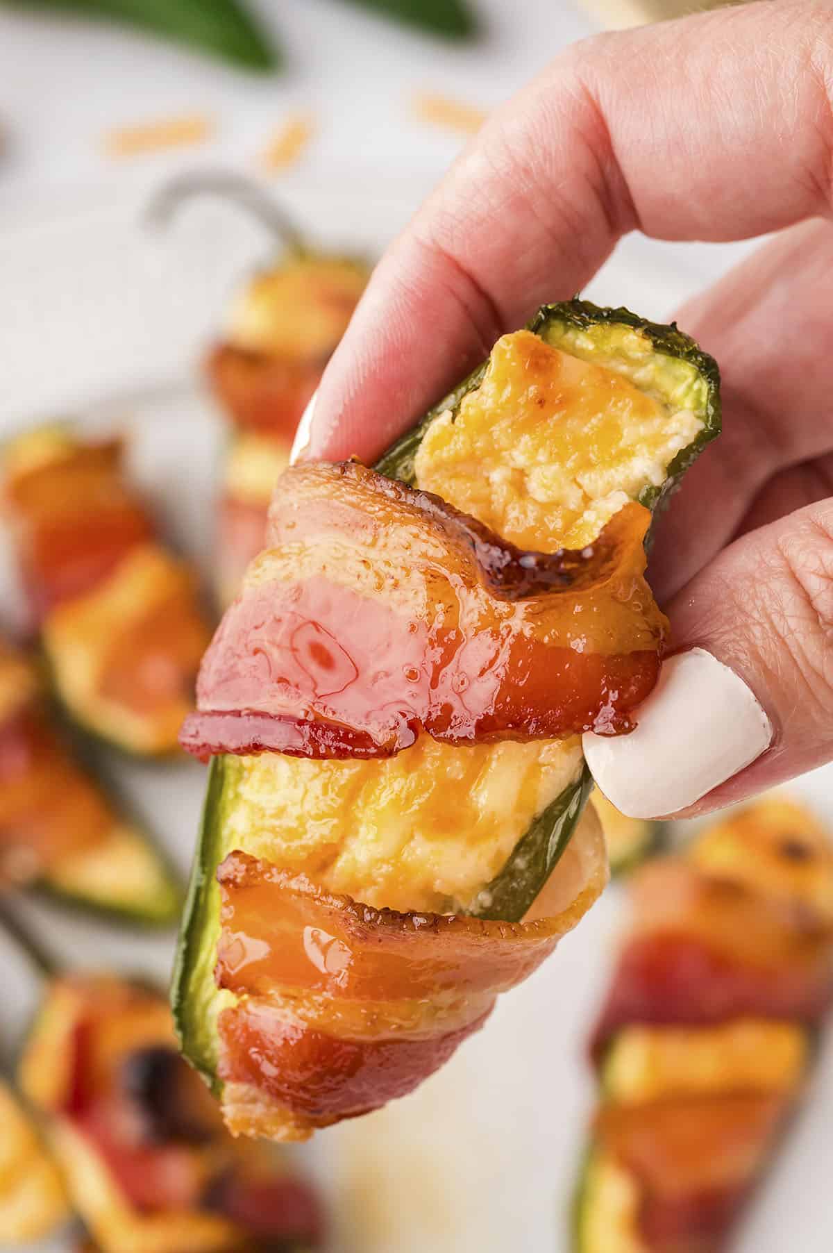 Hand holding a jalapeno popper.