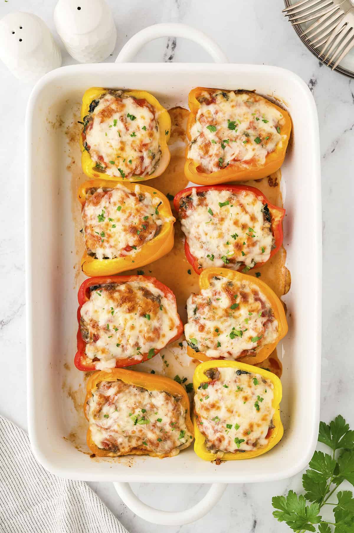 Low carb stuffed peppers in white baking dish.