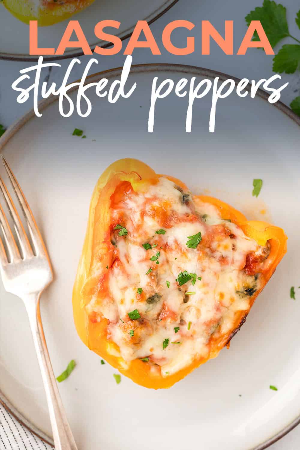 Lasagna stuffed pepper on small white plate next to a fork.