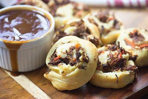 Pot roast pinwheels stacked up on a cutting board.