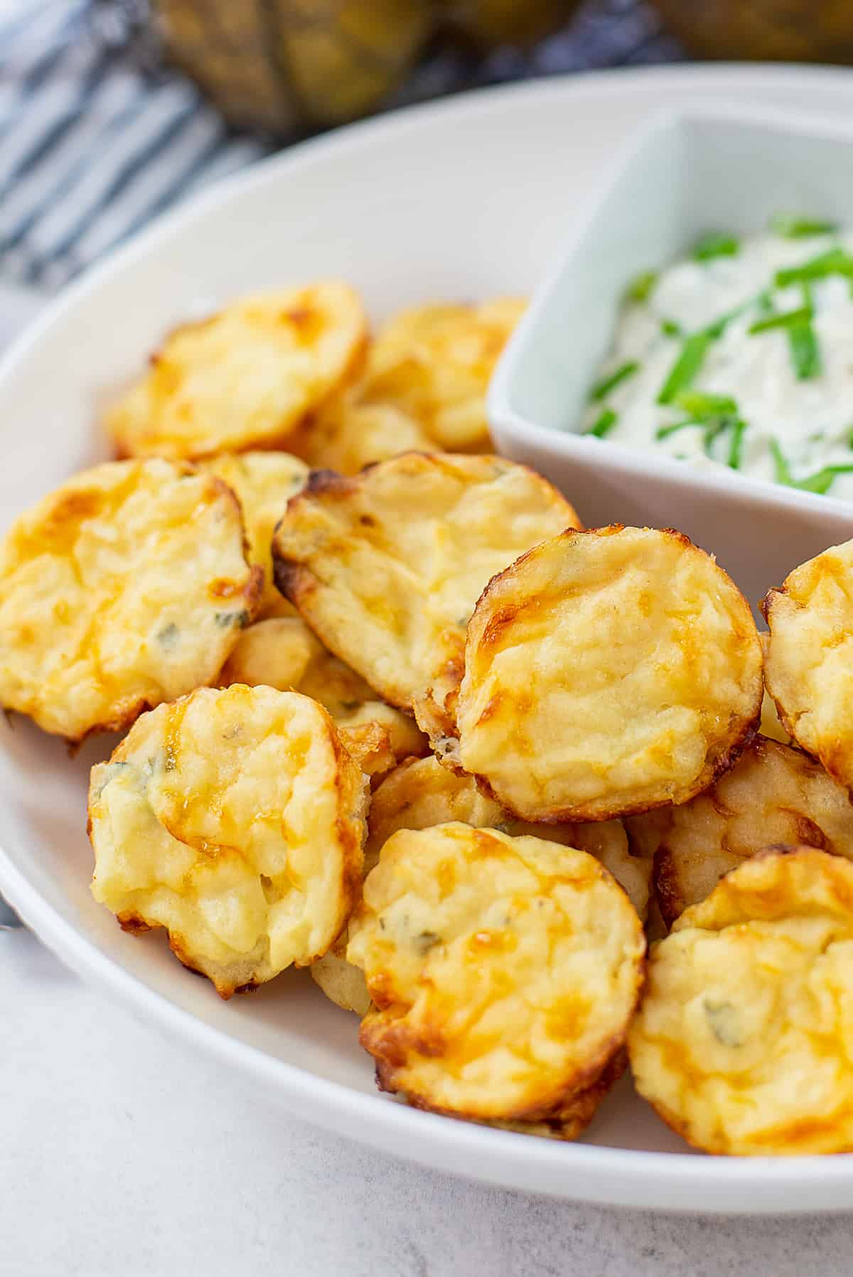 potato puffs in white bowl with ranch.
