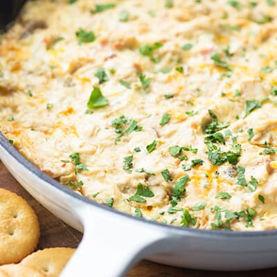 A white cast iron skillet making spicy chicken dip.