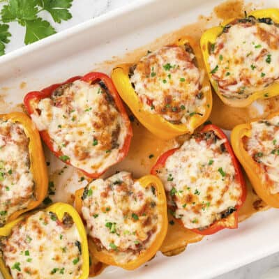 Low carb stuffed peppers in white baking dish.