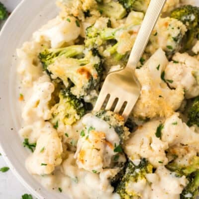Cauliflower and broccoli au gratin on white plate with a fork.