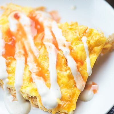 Chicken casserole with ranch drizzled on top of it.