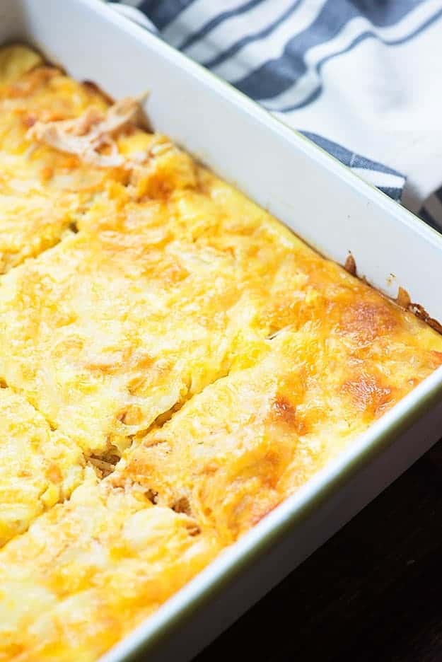 Chicken casserole cut into squares in a white baking pan.