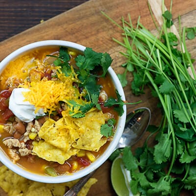 A bowl of taco soup on a wooden serving dish