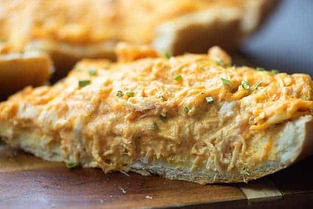 This easy buffalo chicken dip is spread on a loaf of French bread and baked until ooey gooey and melty. So good!