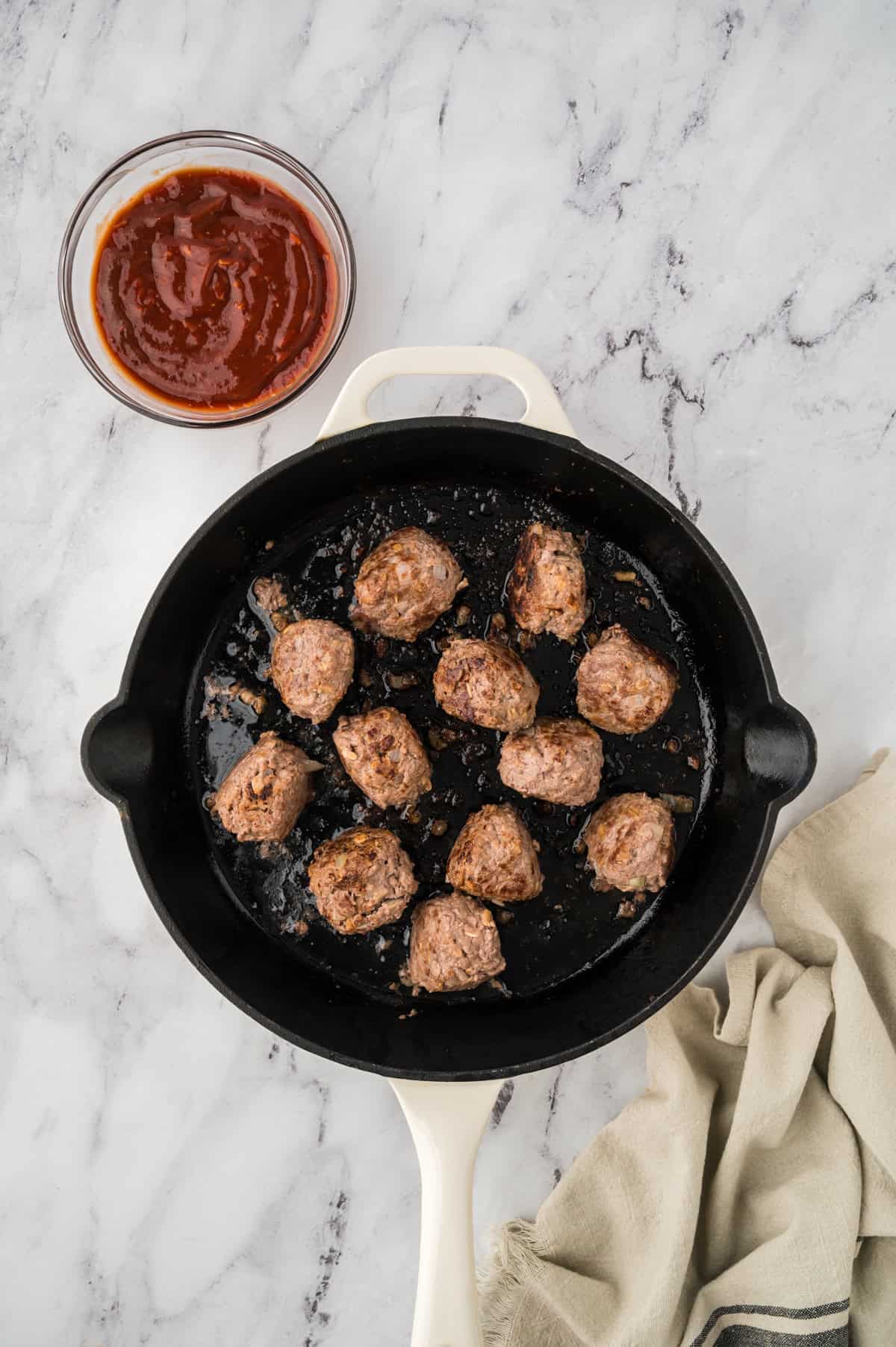 Browned meatballs in skillet.