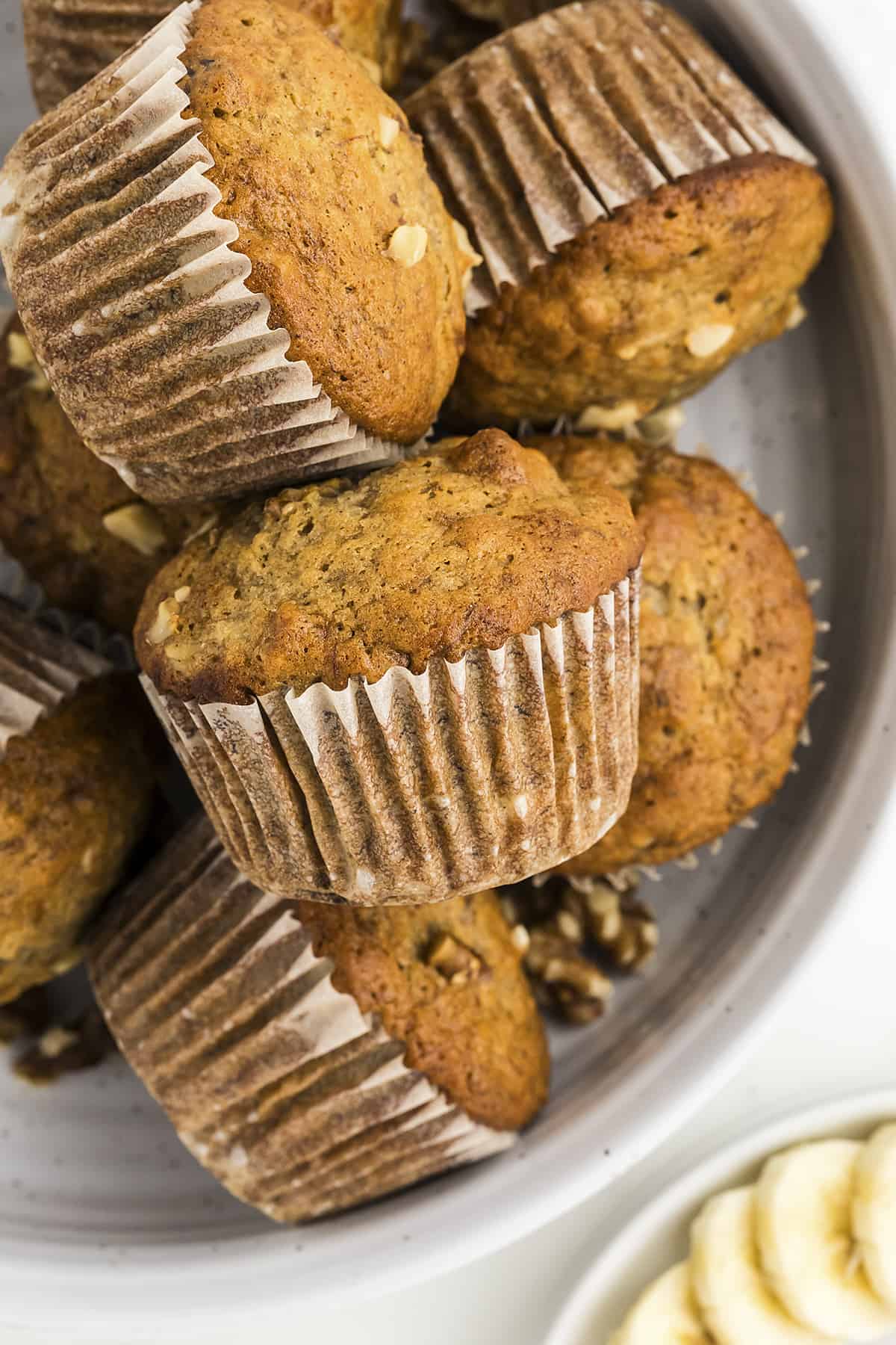 Banana bread muffins piled together on plate.