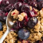 Close up of blueberry crisp on a spoon.