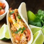 Chicken fajitas sitting on top of lime wedges.
