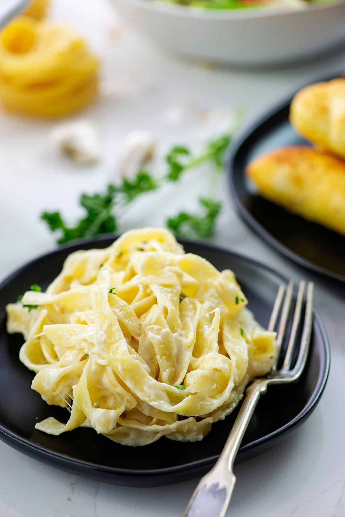 Plate full of fettucine alfredo with a fork.