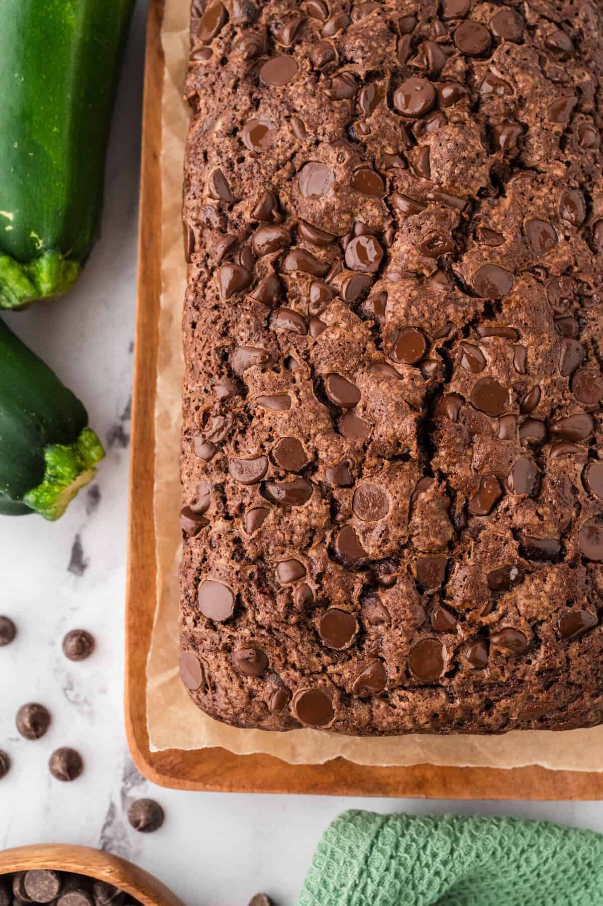 Chocolate chocolate chip zucchini bread on wooden cutting board.