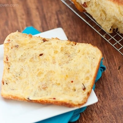 Cheesy pull-apart bread on a small square plate.