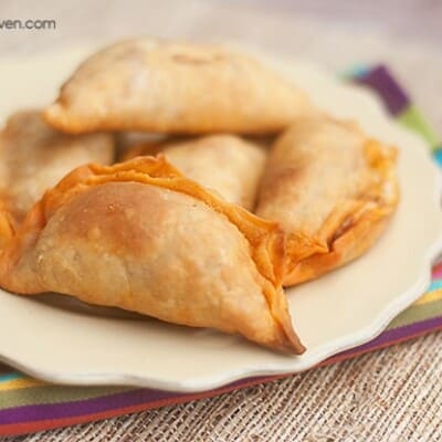 A close up empanadas on a small decorative plate.