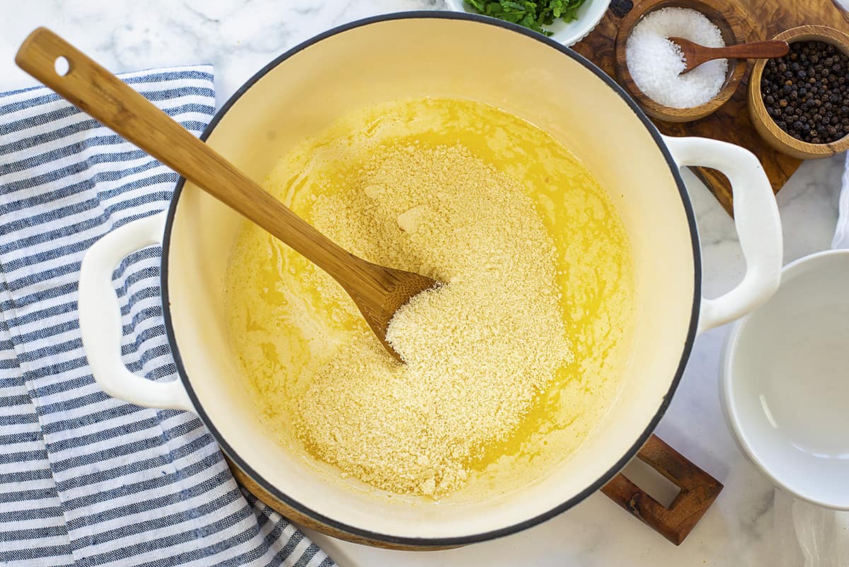 Alfredo sauce cooking in large pot.