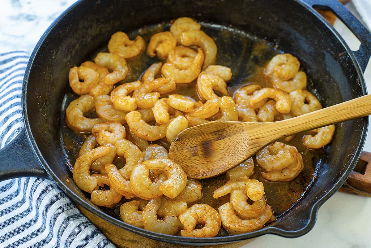 Shrimp cooking in cast iron skillet.