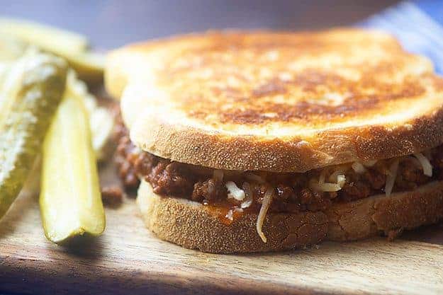 sloppy joe sandwich on wooden cutting board