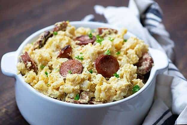 smoked sausage and cheesy potatoes in white dish