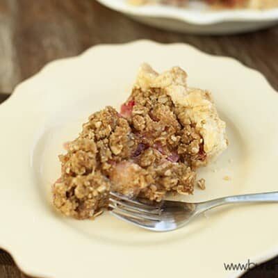 The piece of strawberry rhubarb pie and a fork on a plate