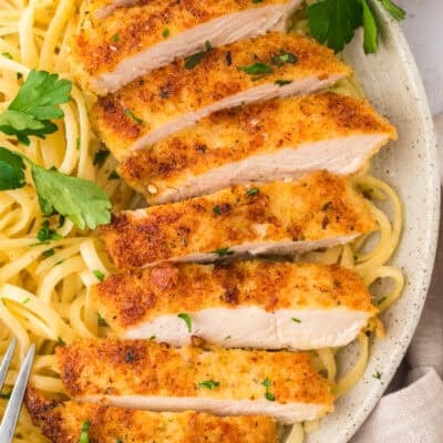 Parmesan crusted chicken sliced into strips and served with pasta.