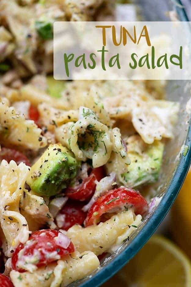 A clear glass bowl of pasta salad.