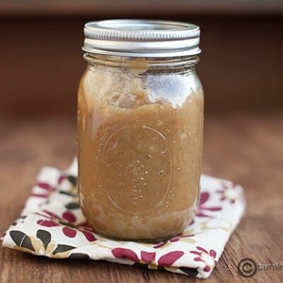 A jar of applesauce on a folded cloth napkin