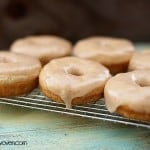 Six brown butter glazed donuts on a cooling rack.