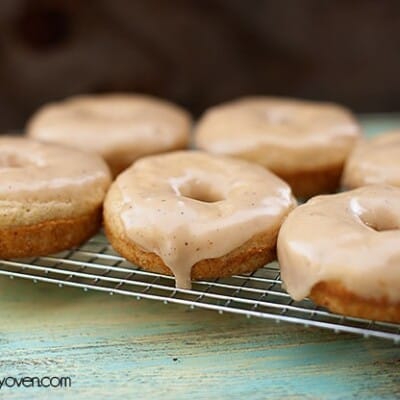 Six brown butter glazed donuts on a cooling rack.