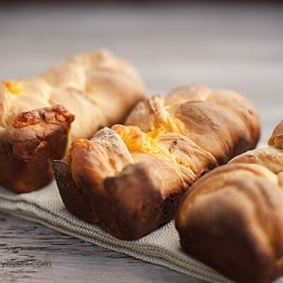 A close up of three pieces of beer cheese bread.