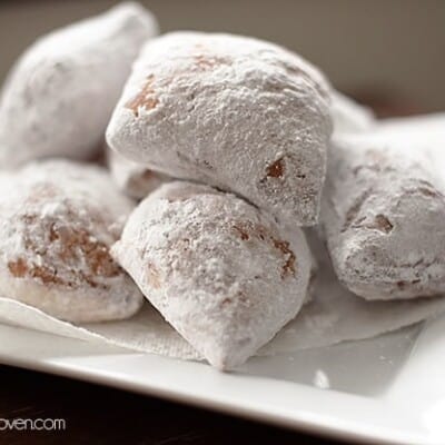 Beignets stacked on a paper napkin.