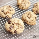 A few chocolate chip cookies on a wire cooking rack.
