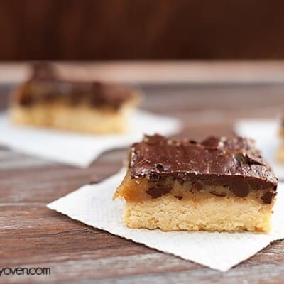 Chocolate caramel bars on napkins spread out on a table.